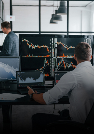 Man in front of stock market screens