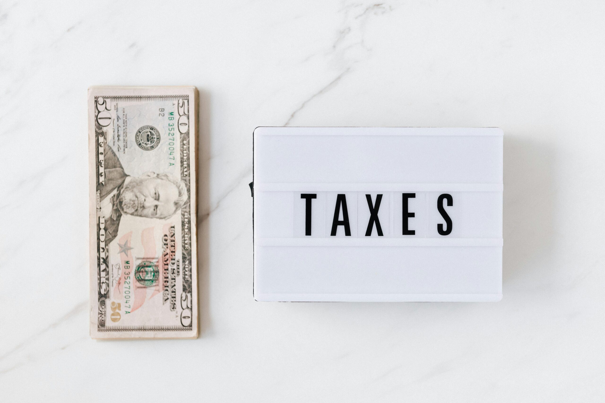 Money next to "taxes" sign